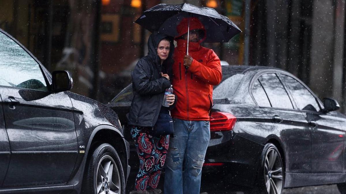 Pedestrians try to avoid a soaking as they wait to cross J Street in downtown Sacramento in 2018. Sacramento Isn’t expecting much rain this week, but could see temperatures drop to freezing.