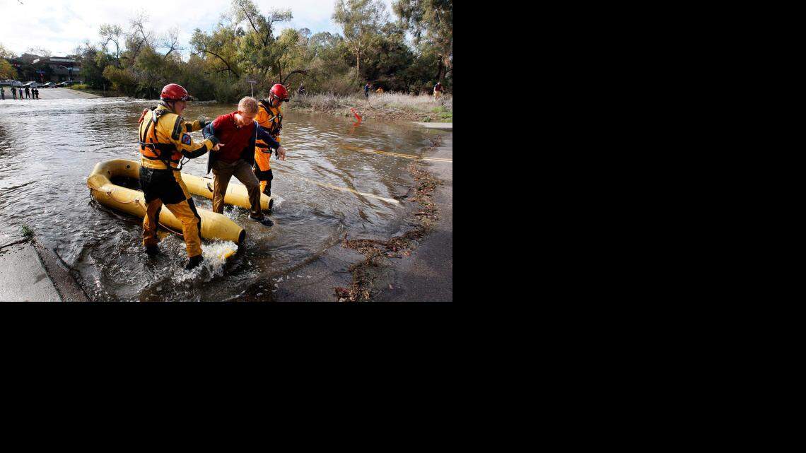 San Diego Fire Rescue Department lifeguards rescue a man from the San Diego River on Thursday. He skirted barricades, then fell into the water.