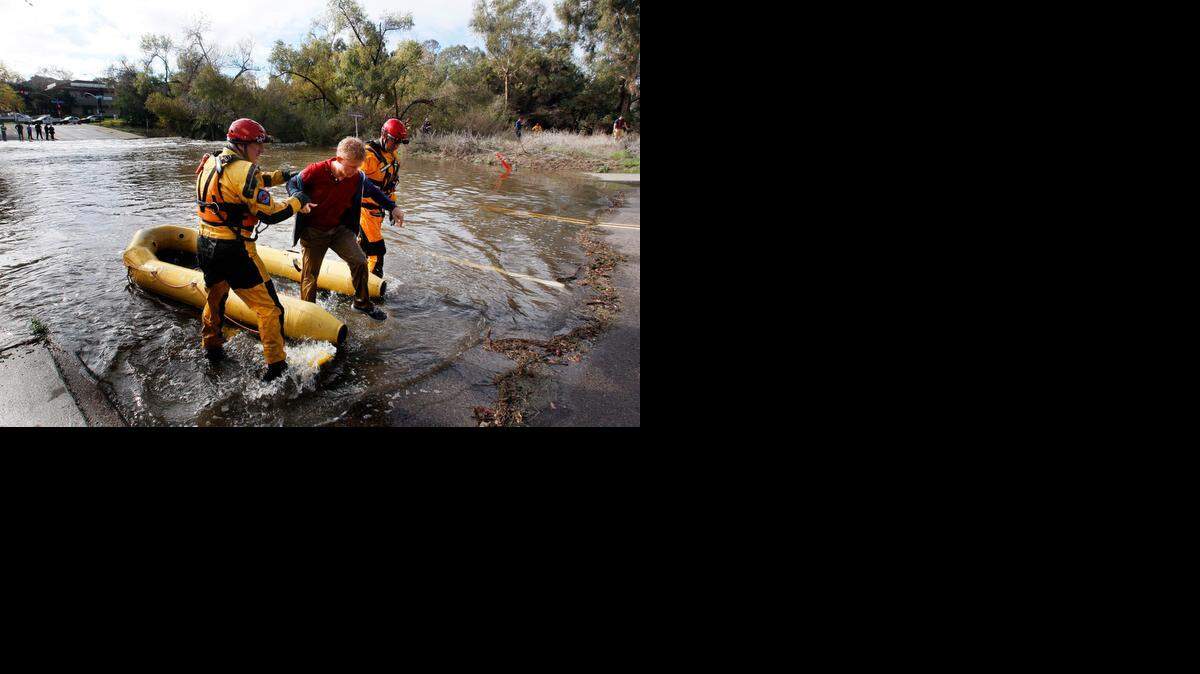 San Diego Fire Rescue Department lifeguards rescue a man from the San Diego River on Thursday. He skirted barricades, then fell into the water.