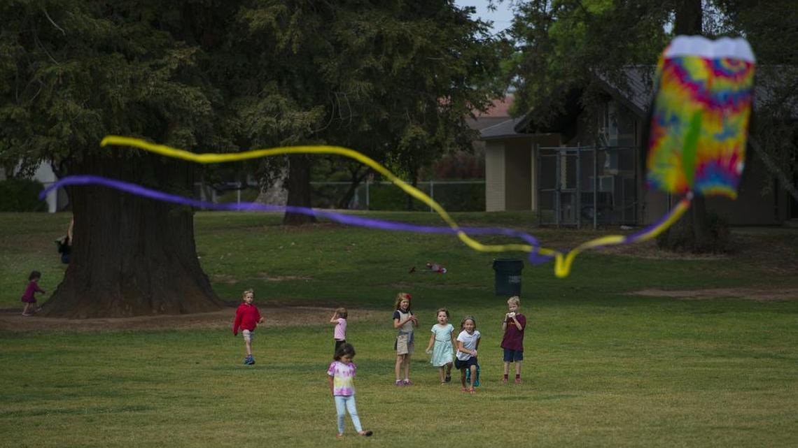Ty Ingle brings down his kite as children play on Tuesday, April 21, 2015 on a windy day at East Portal Park in East Sacramento. It will be breezy today, as well.