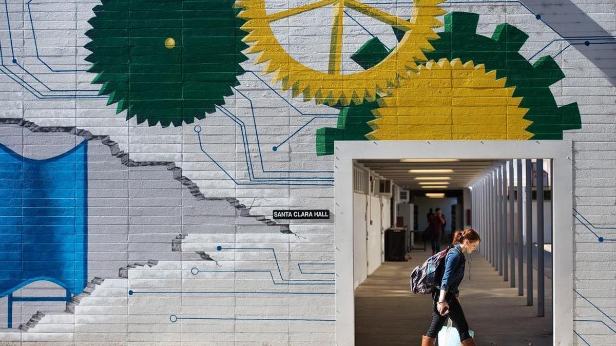 
A student is framed by a hallway as she walks past Santa Clara Hall where an engineering department mural decorates the wall at Sacramento State on Monday, October 12, 2015, in Sacramento.
