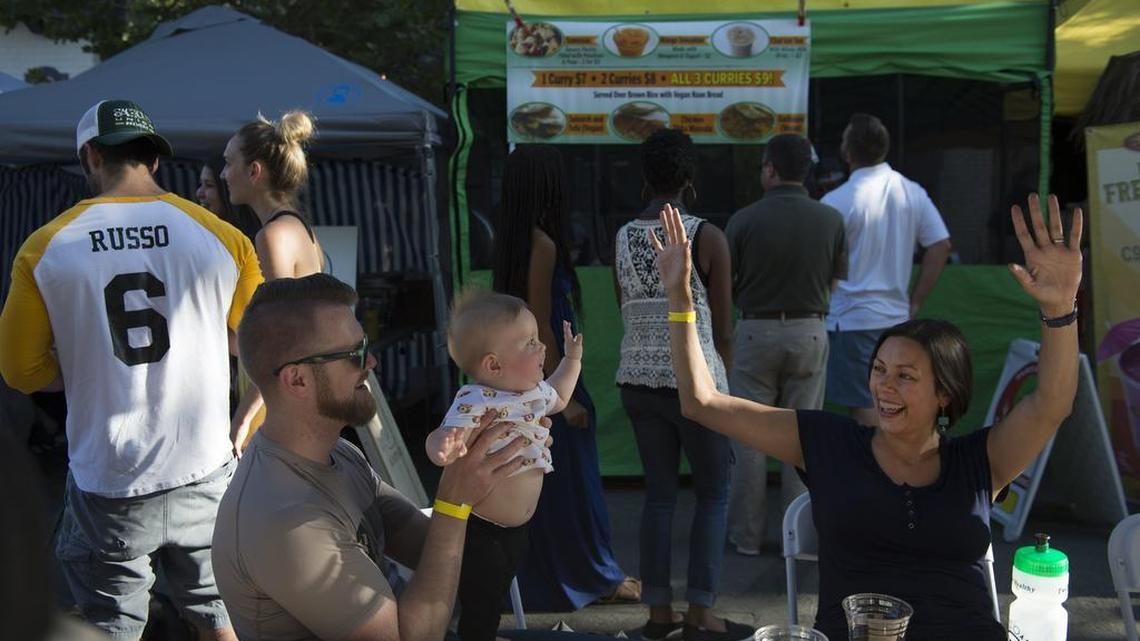 Oak Park residents Crystal Haswell dances to music played by a DJ, with her daughter Sierra, 8 months, held by her husband Phaeton Parker at Gather on June 9, 2016.