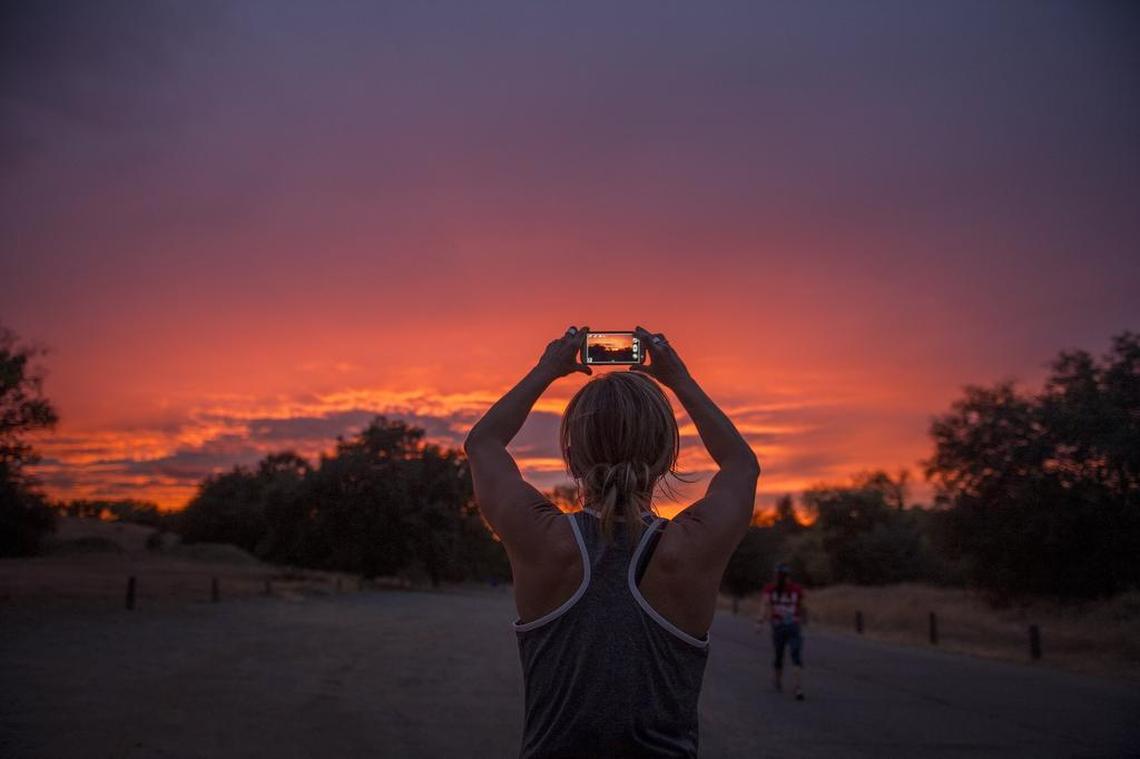 Dana Scapula, 41, photographs the sunset following her run with a group of Fleet Feet woman runners training on Wednesday Sept. 30, 2015, on the American River Parkway in Gold River in preparation for the Nike Women's Half in San Francisco.