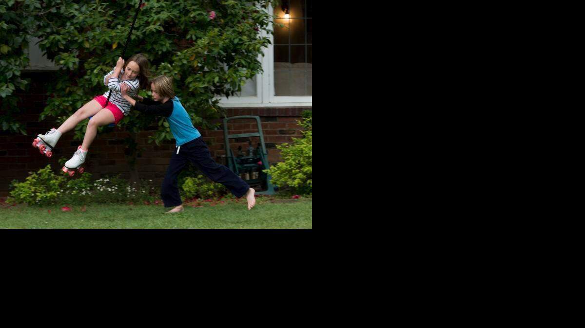 
Chloe Schneider, 8, left, and her brother Joshua Schneider, 11, right, burn off their Easter candy taking turns on their new tree swing, taking advantage of the cool weather before the rain hit on Sunday, April 5, 2015, in east Sacramento. “They have lots of energy after eating candy this morning,” said their dad, Mike Schneider, who put up the swing last week.

