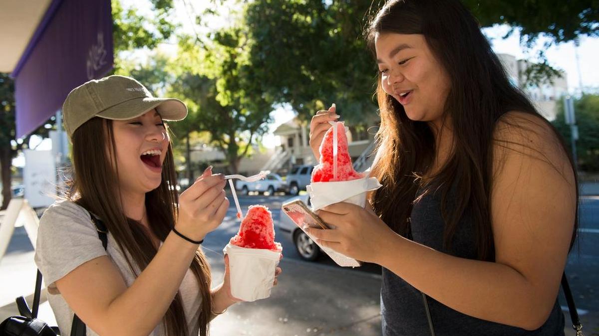 Fonda Lee, 25, and Carol Nguyen, 19, cool off with shaved ice at Osaka-Ya in 2017 as Sacramento experienced unseasonably high temperatures.