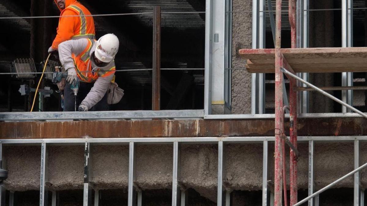 A construction worker drills inside the shell of a building near Macy’s that will house restaurants and other retail outlets on Jan. 24.