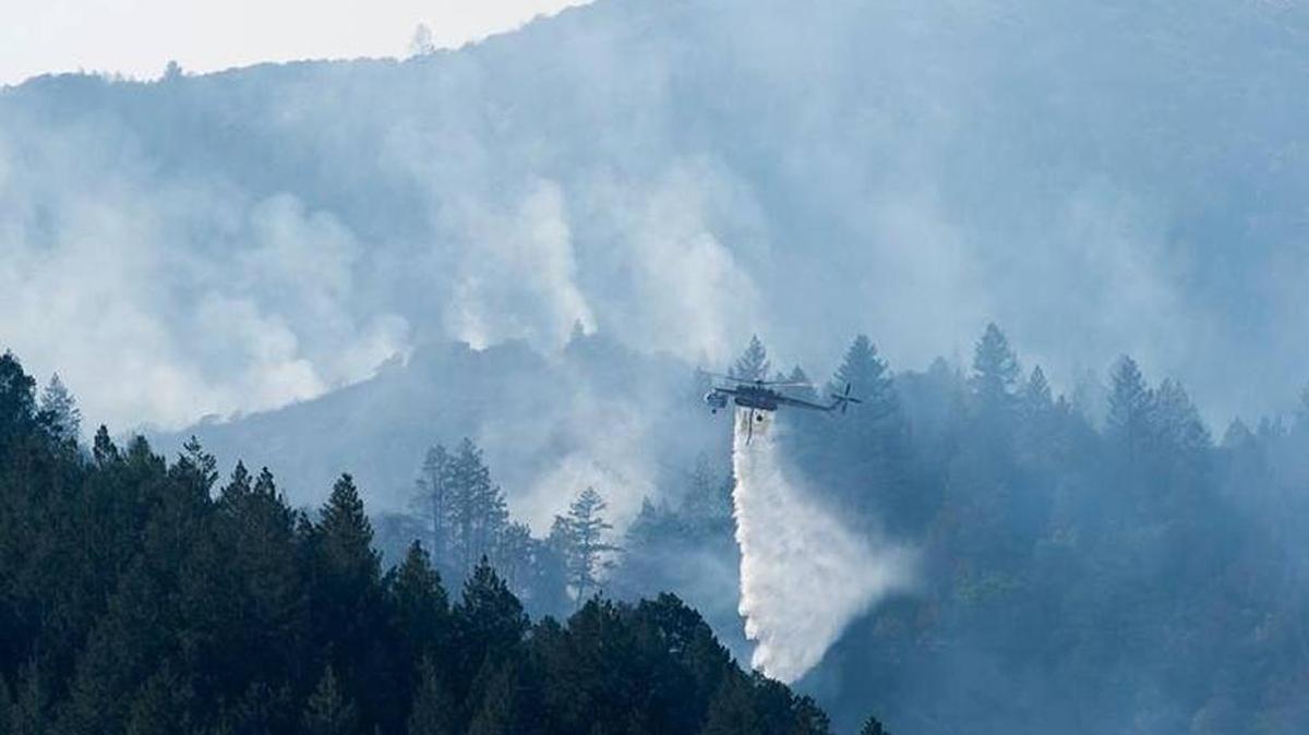 Helicopters battle fire in the mountains between Highway 29 and Highway 12 on Sunday October 15, 2017, near Oakville, Calif. in the Napa Valley.