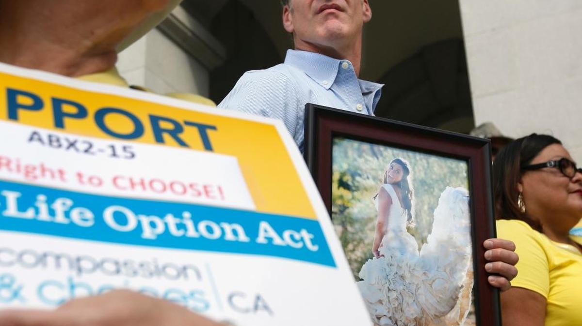 Dan Diaz holds a photo of his late wife, Brittany Maynard, taken on their wedding day, during a rally calling for Gov. Jerry Brown to sign right-to-die legislation in this 2015 file photo. A California judge on May 15, 2018, threw out a 2016 state law allowing the terminally ill to end their lives, ruling it was unconstitutionally approved by the Legislature. Maynard moved to Oregon from California to legally end her life in 2014. (AP Photo/Rich Pedroncelli, File)