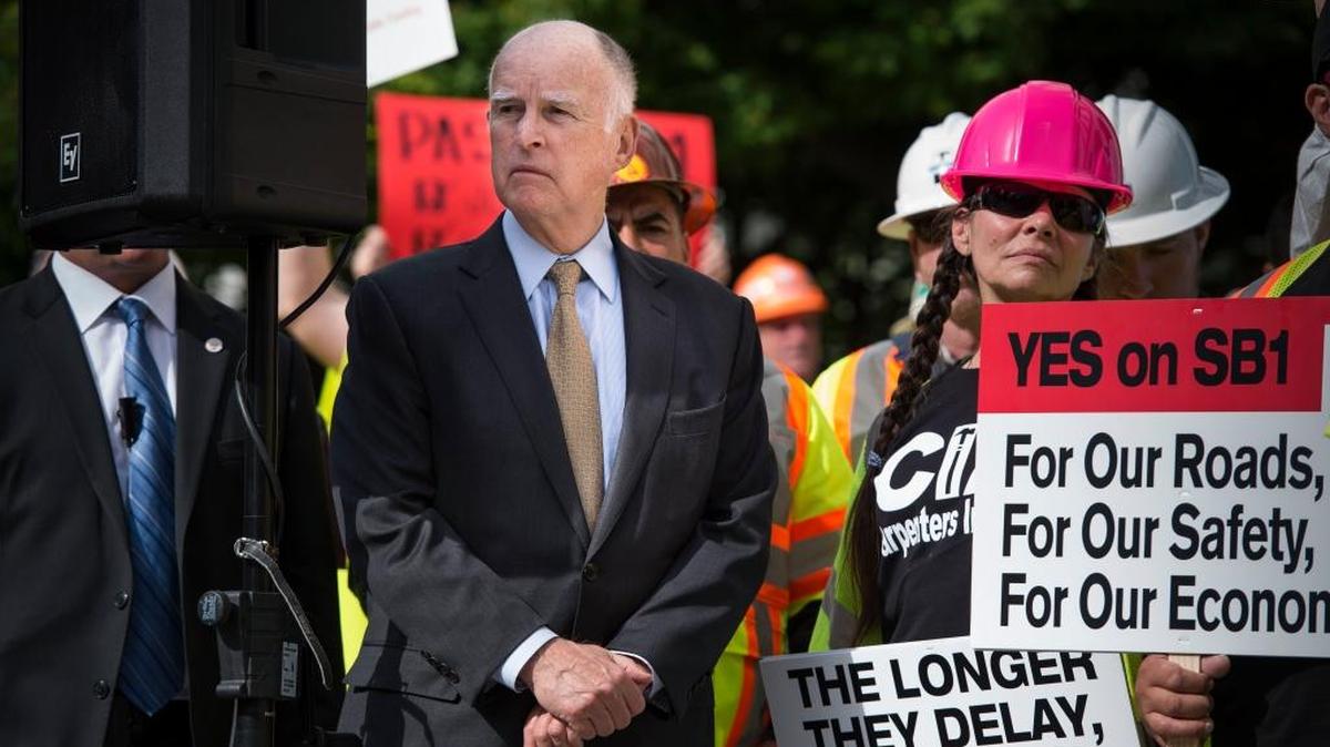 Gov. Jerry Brown with legislators and labor leaders at a 2016 rally for SB1, The Road Repair and Accountability Act of 2017. California is among 26 states to raise transportation fees and taxes in the past several years.