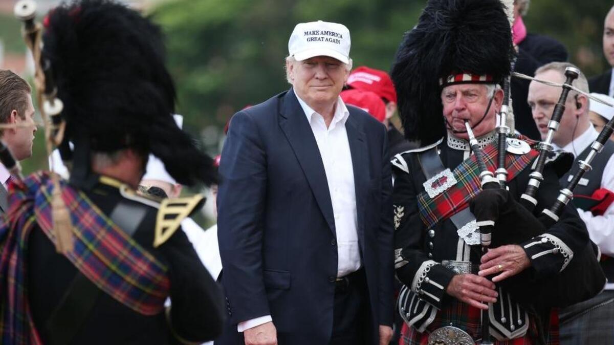 Presumptive Republican presidential nominee Donald Trump poses with a bagpiper as he arrives at his revamped Trump Turnberry golf course in Turnberry, Scotland, on Friday. Trump saluting the United Kingdom’s vote to leave the European Union, saying, “They took back their country, it’s a great thing.”