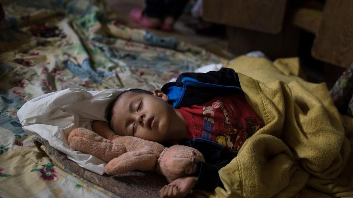 A Central American child who is traveling with a caravan of migrants sleeps at a shelter in Tijuana, Mexico, Sunday, April 29, 2018. Under a new, harsher policy, U.S. authorities are seizing the children of parents who illegally come to the country to seek asylum and sending them to separate detention facilities in other states. (AP Photo/Hans-Maximo Musielik)