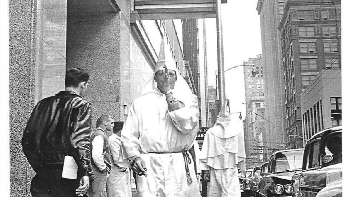 A Ku Klux Klan member thumbs his nose at the photographer while protesting outside the Atlanta Journal-Constitution building in December 1960. The KKK was protesting integration at lunch counters and Ralph McGill, the editor and daily columnist of the Atlanta Constitution who opposed segregation. McGill won a Pulitzer Prize for editorial writing in 1959.