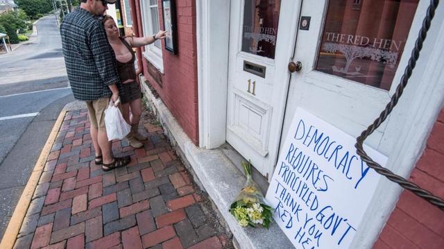 Passersby examine the menu at the Red Hen Restaurant Saturday, June 23, 2018, in Lexington, Va. White House press secretary Sarah Huckabee Sanders said Saturday in a tweet that she was booted from the Virginia restaurant because she works for President Donald Trump. (AP Photo/Daniel Lin)/Daily News-Record via AP)