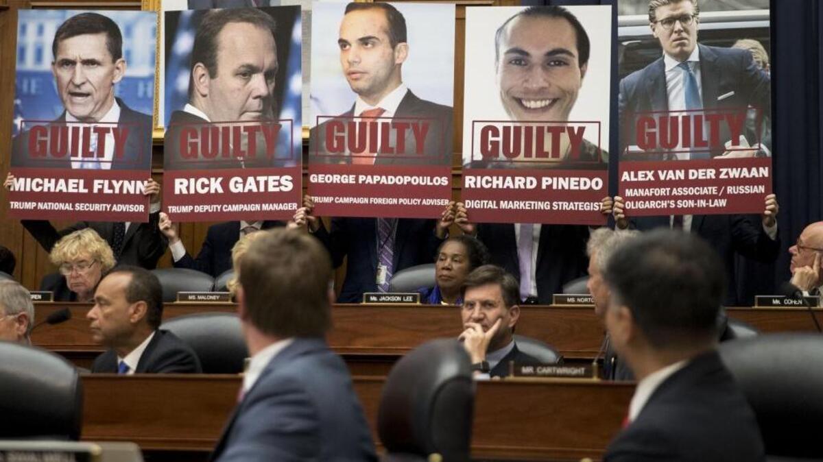 Posters of people who have plead guilty in special counsel Robert Mueller’s probe into Russian interference in the U.S. elections are held by staff members during a joint House Judiciary, Oversight and Government Reform Committees hearing with FBI agent Peter Strzok.