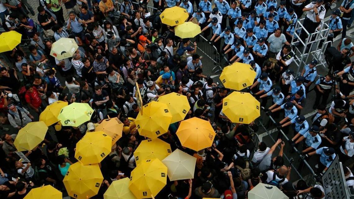 Protesters holding yellow umbrellas gather outside government headquarters to observe the first anniversary of Hong Kong’s “Umbrella Movement” for universal suffrage. In recent months, the movement’s leaders have been arrested and charged. (AP Photo/Kin Cheung)