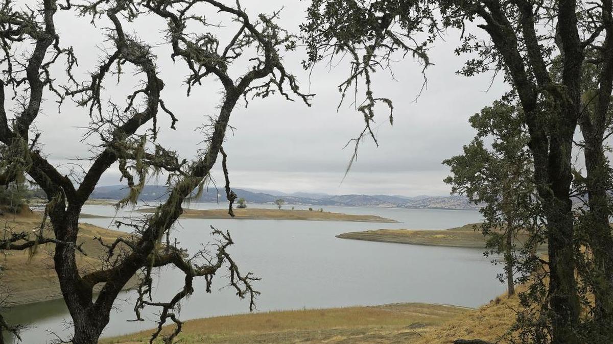 Trees frame Lake Berryessa with California’s newest national monument in the background, July 10, 2015, near Berryessa Snow Mountain National Monument. The designation covers hundreds of thousands of acres from marshes to the mountain peaks 6,000 feet above them, but President Donald Trump has been rolling back protections for monuments nationally. (AP Photo/Eric Risberg)