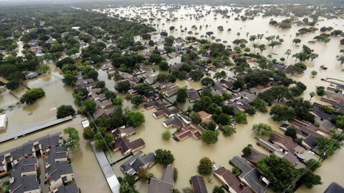 In this Tuesday, Aug. 29, 2017, file photo, water from Addicks Reservoir flows into neighborhoods as floodwaters from Tropical Storm Harvey rise in Houston. (AP Photo/David J. Phillip, File)