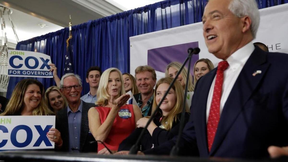 Republican gubernatorial candidate John Cox, right, speaks during a Republican election party Tuesday, June 5, 2018, in San Diego. With their daughter, Julianne, between them, his wife Sarah Cox blows him a kiss. (AP Photo/Gregory Bull)