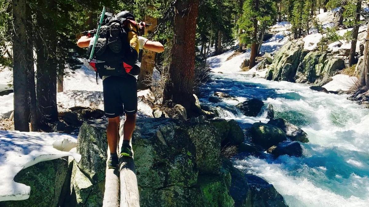 A hiker crosses Bear Creek along the Pacific Crest Trail near Kings Canyon National Park on Friday, June 16, 2017. A bill by Rep. Tom McClintock would open this and other wilderness areas to mountain biking. (Wesley Tils via AP)