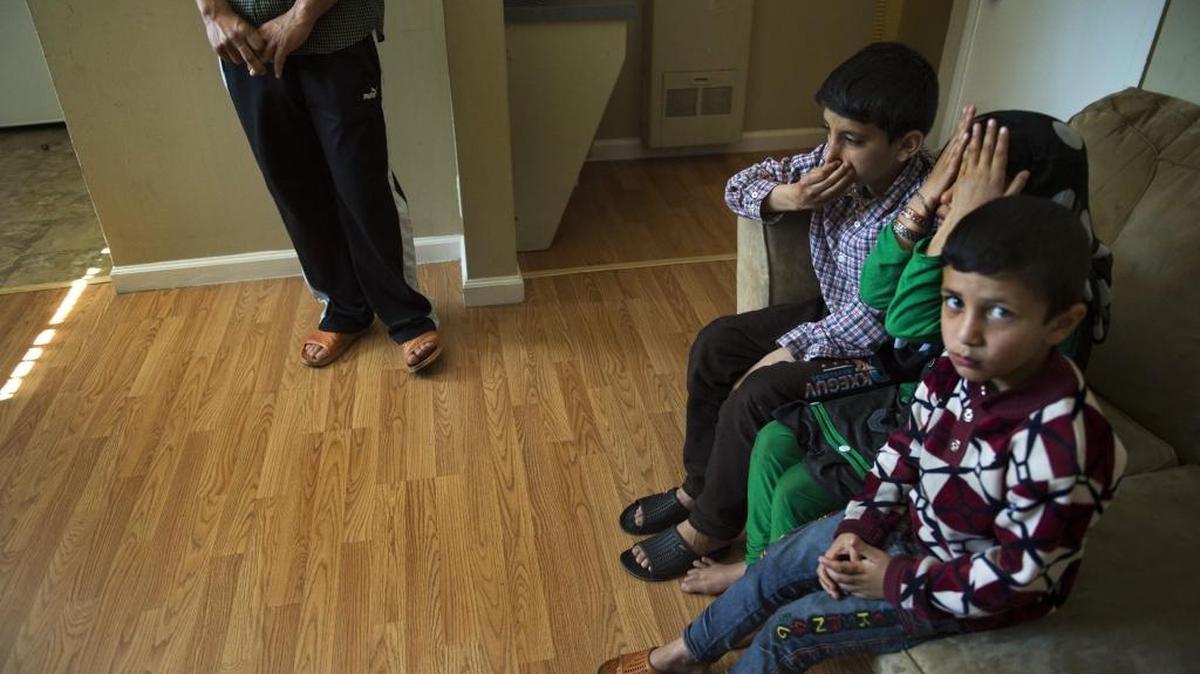 Afghan children react in 2016 to the smell at the Arden Arcade apartment where their family has been resettled. An influx of refugees from Syria, Afghanistan, Iraq and elsewhere have intensified poverty in the neighborhood, along with demand at the local food bank.