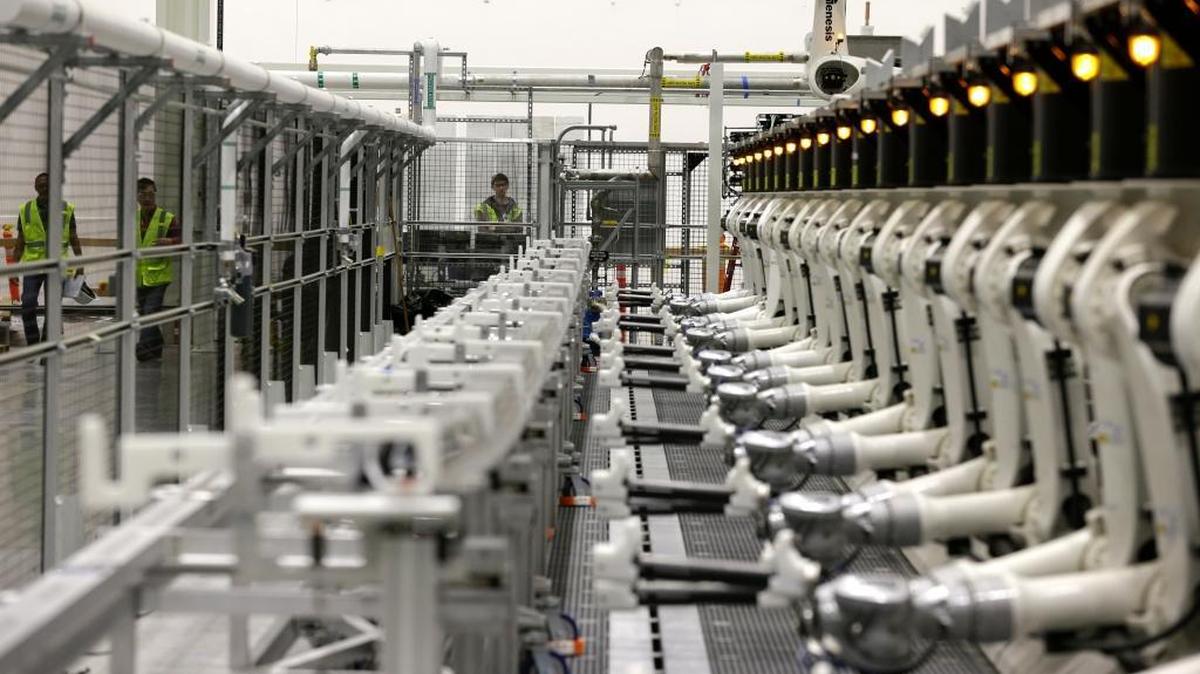 Workers test robotic arms on a machine that will be used to perform water-based ultrasonic tests on wing parts at Boeing's 777X Composite Wing Center, Monday, June 12, 2017, in Everett, Wash. (AP Photo/Ted S. Warren)