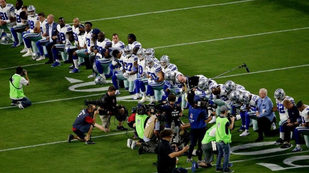The Dallas Cowboys, led by owner Jerry Jones, far right, take a knee prior to the national anthem on Monday. Popularized by former San Francisco 49er Colin Kaepernick as a protest against police brutality and racial injustice, the gesture has swept the nation since President Donald Trump called Kapernick a “son of a bitch.” (AP Photo/Matt York)