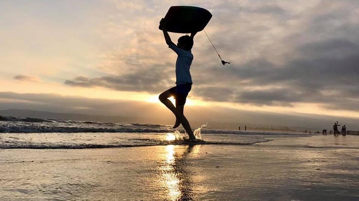 The author’s son romps at dusk with a boogie board on Coronado Beach in San Diego County.