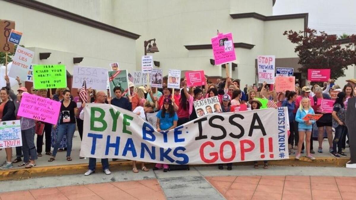 While a large audience waits in an Orange County high school auditorium to hear Republican Rep. Darrell Issa speak at a town hall, counter-protesters line up outside.