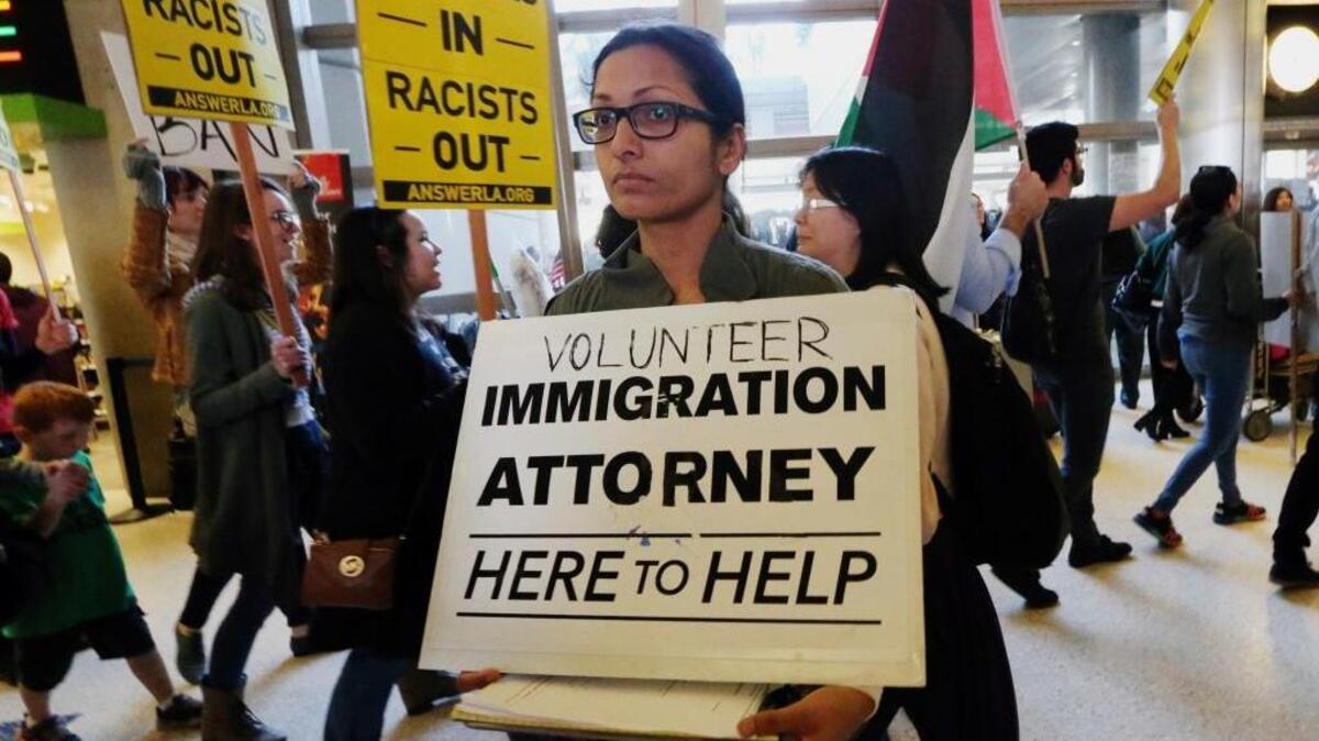 A woman offers legal services at the customs arrival area at the Tom Bradley International Terminal at Los Angeles International Airport on Feb. 4, as demonstrators oppose President Donald Trump’s executive orders barring entry to the U.S. from seven Muslim-dominated countries.