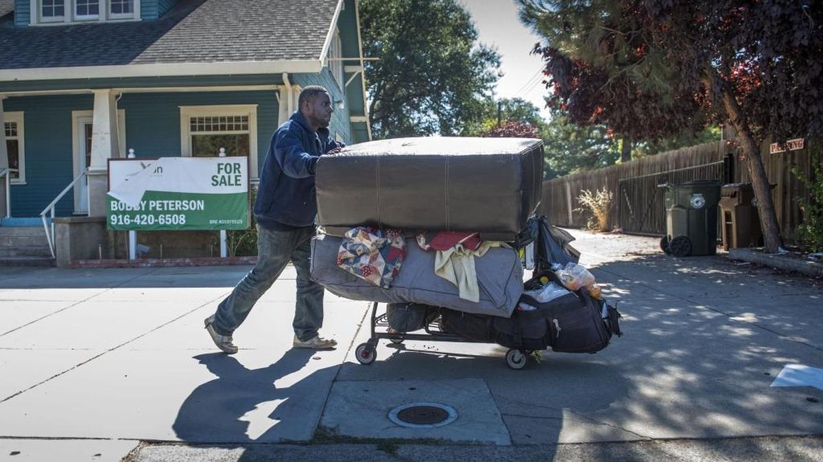Phillip Moore, who graduated from Elk Grove High School in 1994 pushes a cart with his belongings. Moore is among thousands living unsheltered in Sacramento County.
