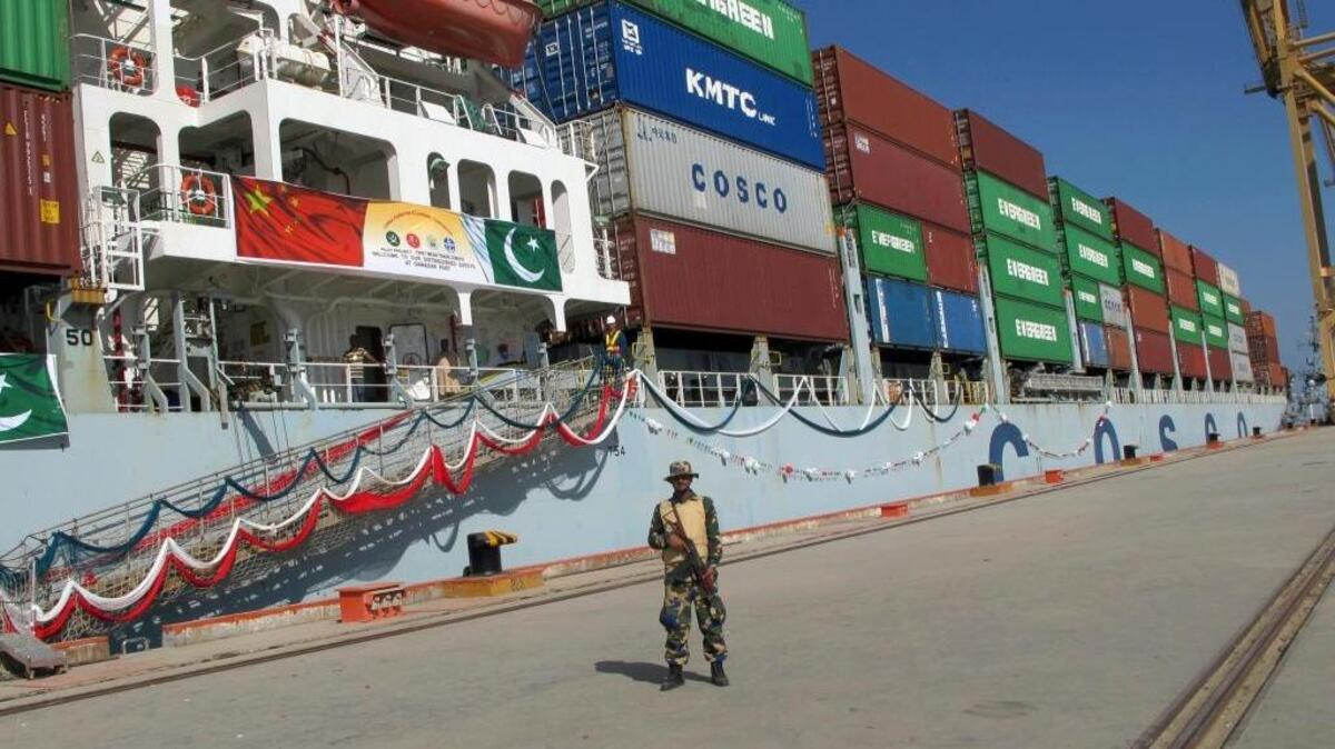 A Pakistan Navy soldier stands guard while a loaded Chinese ship prepares to depart from Gwadar port that links China’s far western region on a new international route exporting goods to the Middle East and Africa. China’s new Silk Road initiative is ramping up.