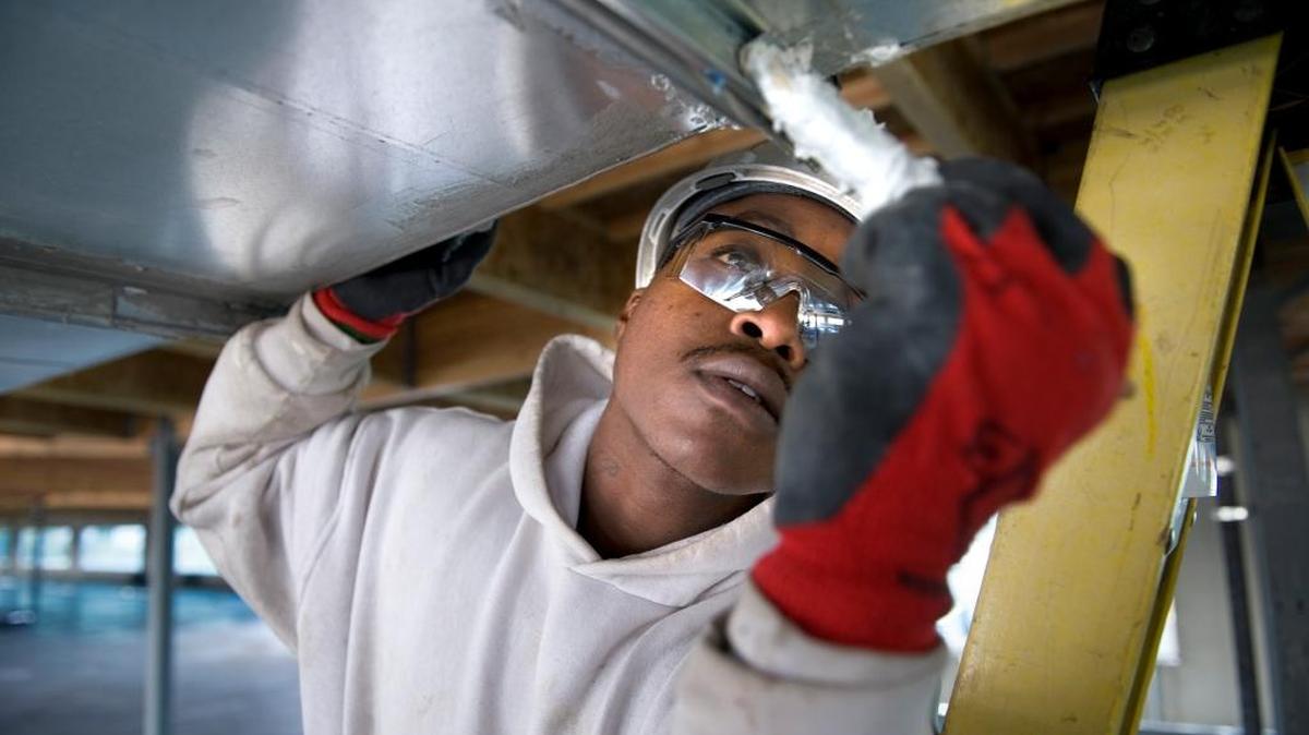 A sheet metal apprentice works on an air duct for BOS Sheet Metal in 2008 in Rancho Cordova, placed there by an Urban League jobs program.