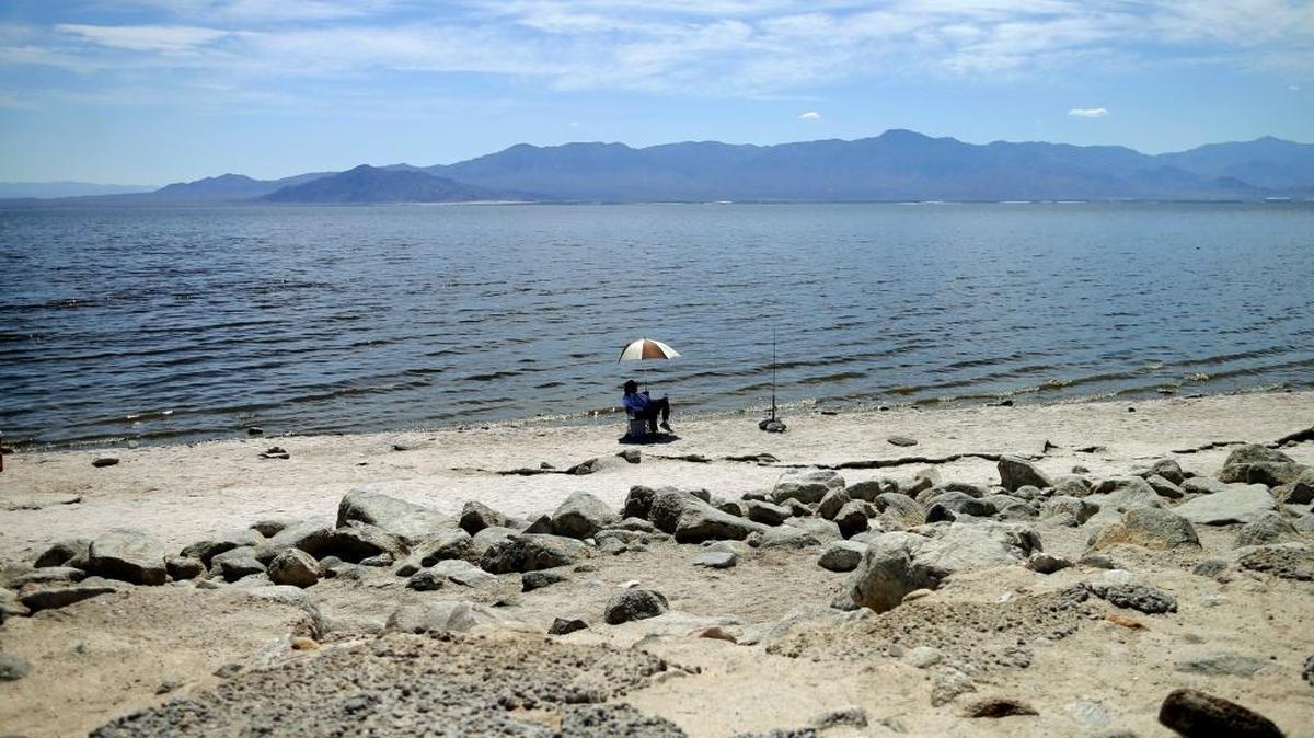 A man fishes for tilapia in 2015 along the receding banks of the Salton Sea near Bombay Beach, Calif. Toxic dust from the shrinking lake poses one of the largest environmental and public health crises in state history. (AP Photo/Gregory Bull, File)
