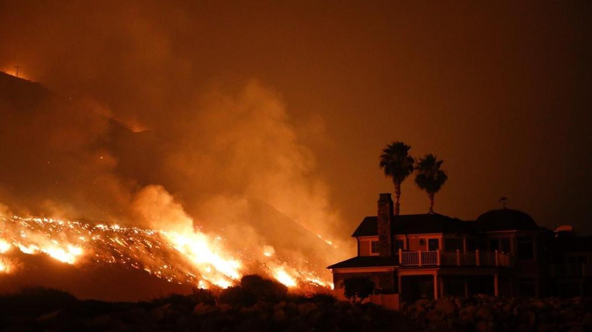 A wildfire threatens homes in December 2017 in Ventura. Billions in losses have created a crisis in homeowners’ insurance in some areas of California.