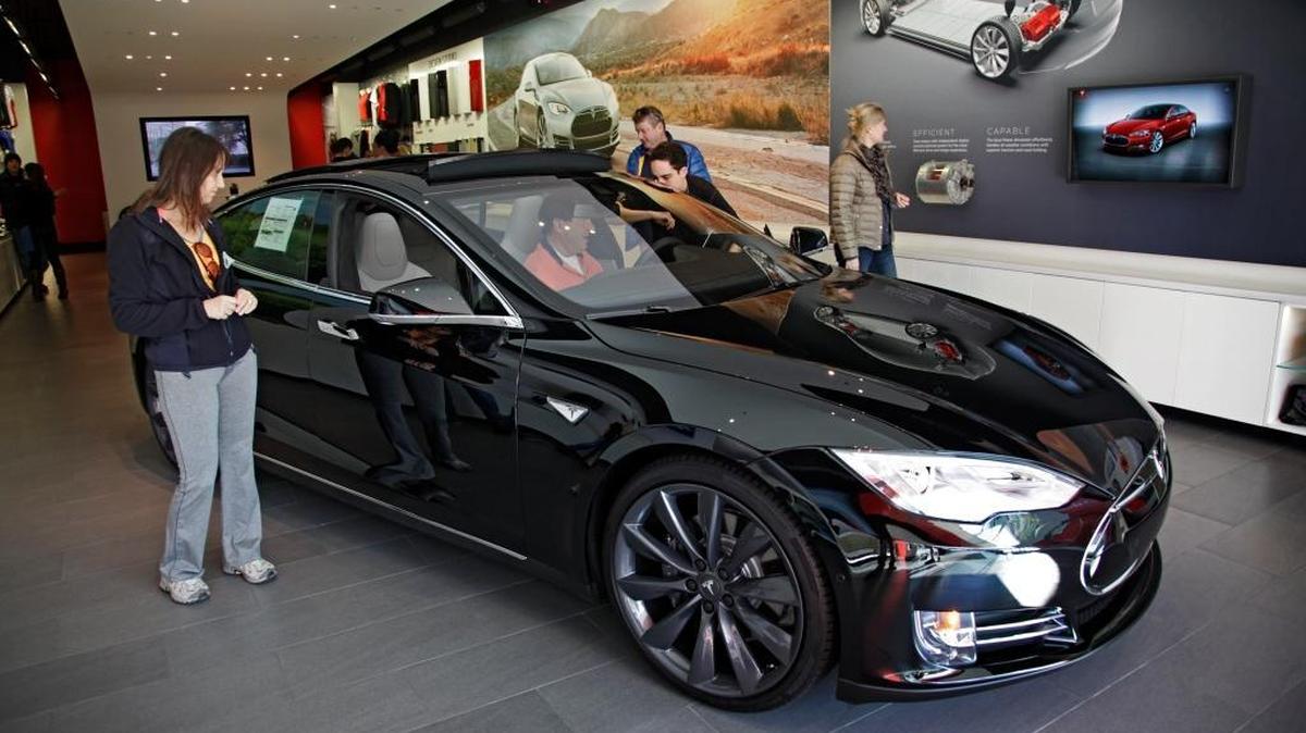 Shoppers check out the Tesla model S at the Tesla showroom at the the Third Street Promenade in Santa Monica.