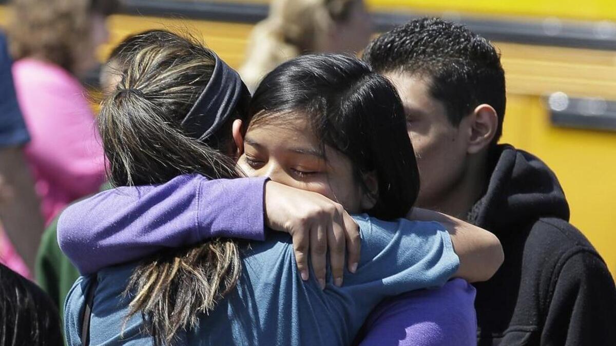Nearly half of adolescent suicides are committed with firearms. Here, students embrace, sobbing, after a 15 year old armed with an assault rifle, a handgun and several magazines of ammunition killed himself and a classmate in 2014 at a high school east of Portland. (AP Photo/Rick Bowmer)