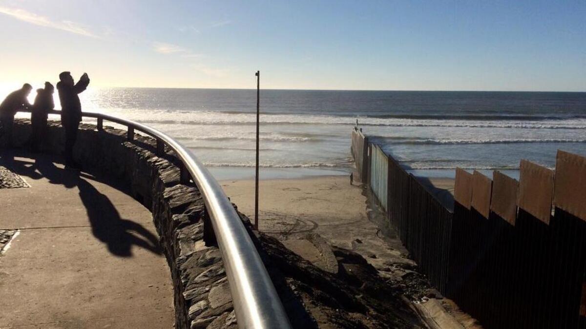 Sightseers take in the border structure separating San Diego from Tijuana, Mexico.