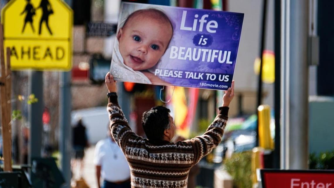 An anti-abortion protester pickets a Van Nuys Planned Parenthood health center in 2017. The Supreme Court this month will hear a free speech challenge to a California law requiring all licensed family planning centers, including those that are pro-life, to post signs informing women about state programs that provide free or low-cost reproductive health care, including abortion. (AP Photo/Richard Vogel)