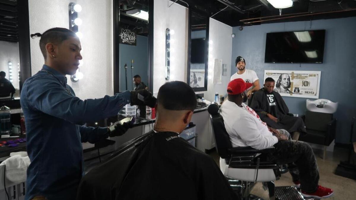 For Isaiah “Zay the Barber” Ford, far right, and The Rich Barber proprietor Chuka Torres, cutting a customer’s hair at far left, their business is as much an incubator as a barbershop.
