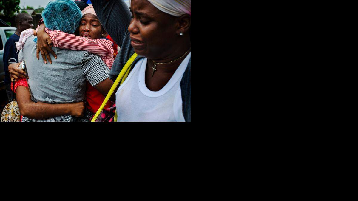 
Women who were among 15 Liberian patients who recovered from Ebola cry as they greet family members after their release from a treatment unit in Monrovia, Liberia, on Sept. 24, 2014.
