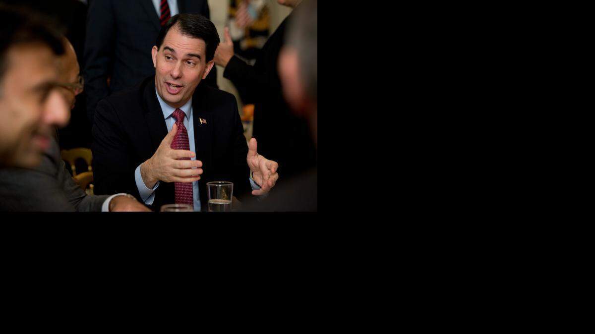 
Wisconsin Gov. Scott Walker talks to people at his table before President Barack Obama speaks to the National Governors Association on Monday. Walker has refused to repudiate Rudy Giuliani’s remarks questioning whether Obama loves America.
