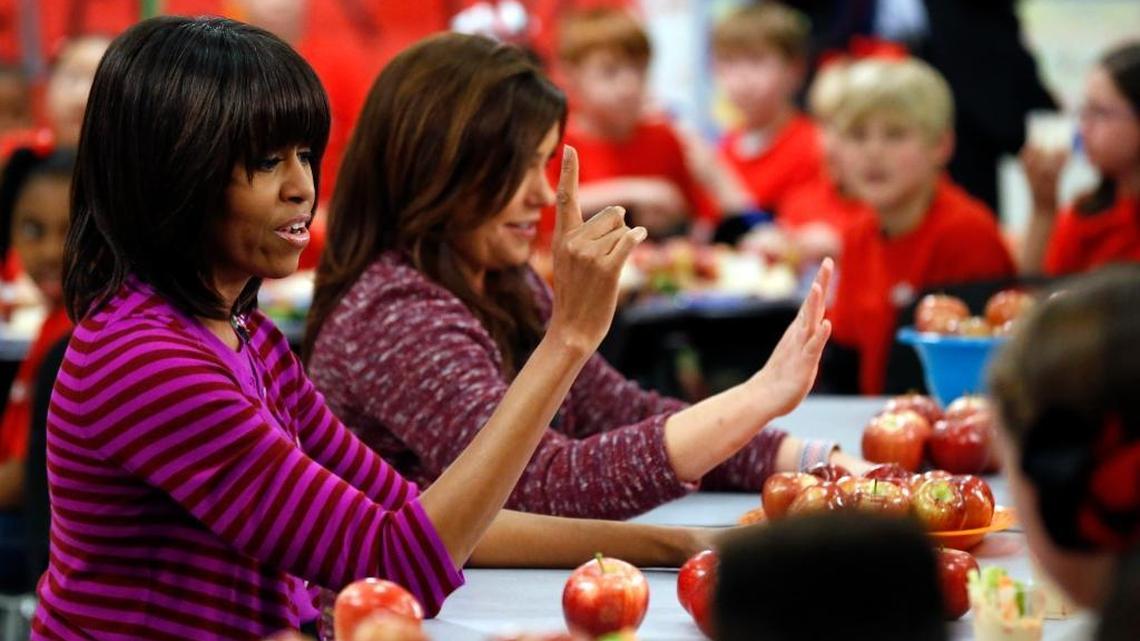 Then-first lady Michelle Obama, left, and Food Network chef Rachael Ray discuss lunch with students from Eastside and Northside Elementary Schools in Clinton, Mississippi, in 2013.