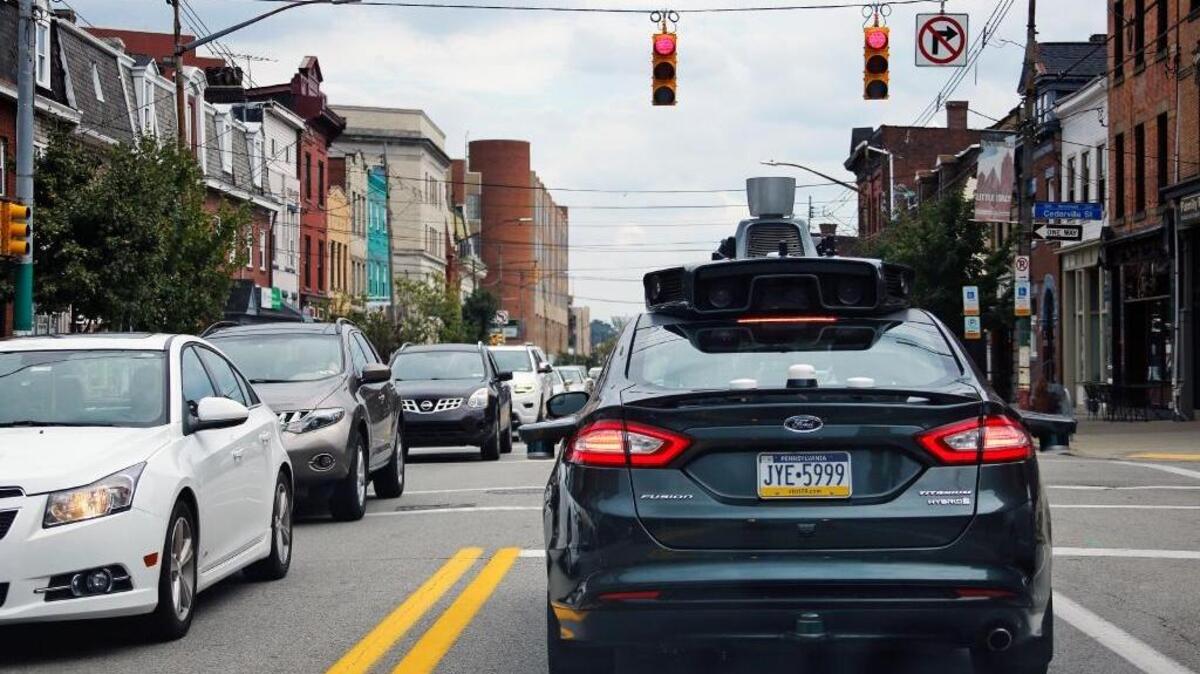 A self-driving Uber drives through Pittsburgh on Wednesday as part of a fleet of self-driving Ford Fusions began picking up riders who opted to participate in a test program.