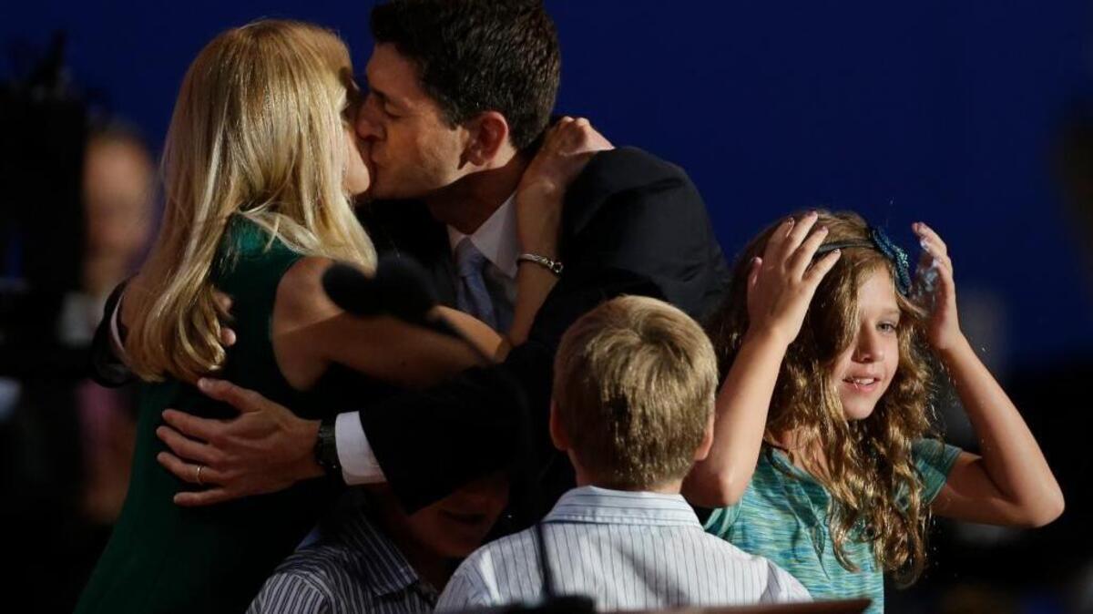 Rep. Paul Ryan kisses his wife, Janna, after his vice presidential acceptance speech during the 2012 GOP National Convention. Daughter Liza is at right.