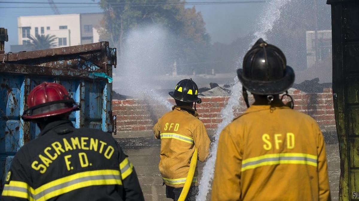 Sacramento Fire Department crews mop up after a fire destroyed a vacant warehouse on R Street in November 2015.