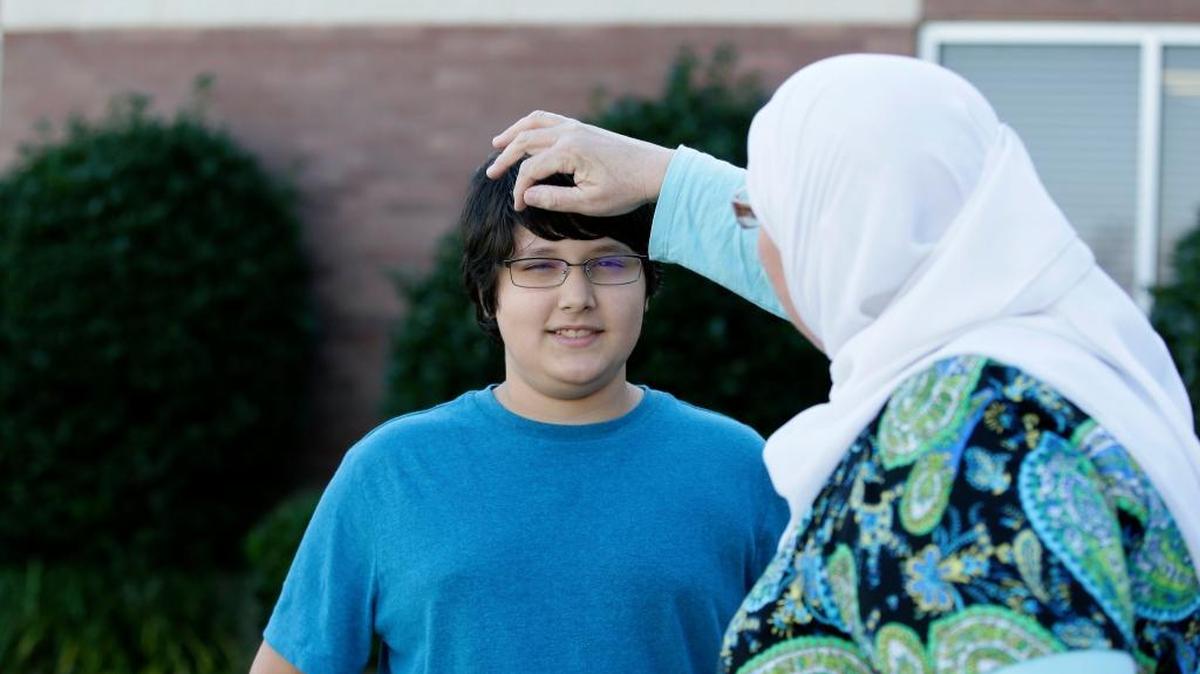 Melissa Walker adjusts the hair of her son, Habib Rahman, 12, in front of his middle school in Rockwall, Texas. Children are processing the outcome of a presidential election that often attacked minorities and immigrants.