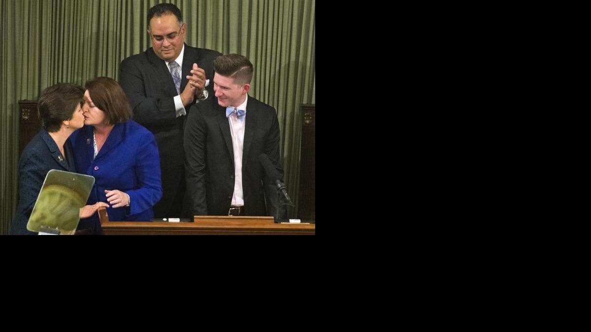 
Toni Atkins, second from left, kisses her wife, Jennifer LeSar, after being sworn in as Assembly speaker on May 12. Also on the dais are outgoing Speaker John A. Perez and Atkins’ nephew Thomas Phillips.
