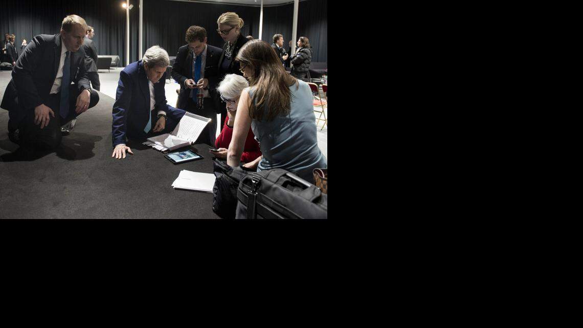 
Secretary of State John Kerry, center, watches on a tablet Thursday in Switzerland as President Barack Obama talks about a framework Kerry helped negotiate on Iran’s nuclear program.
