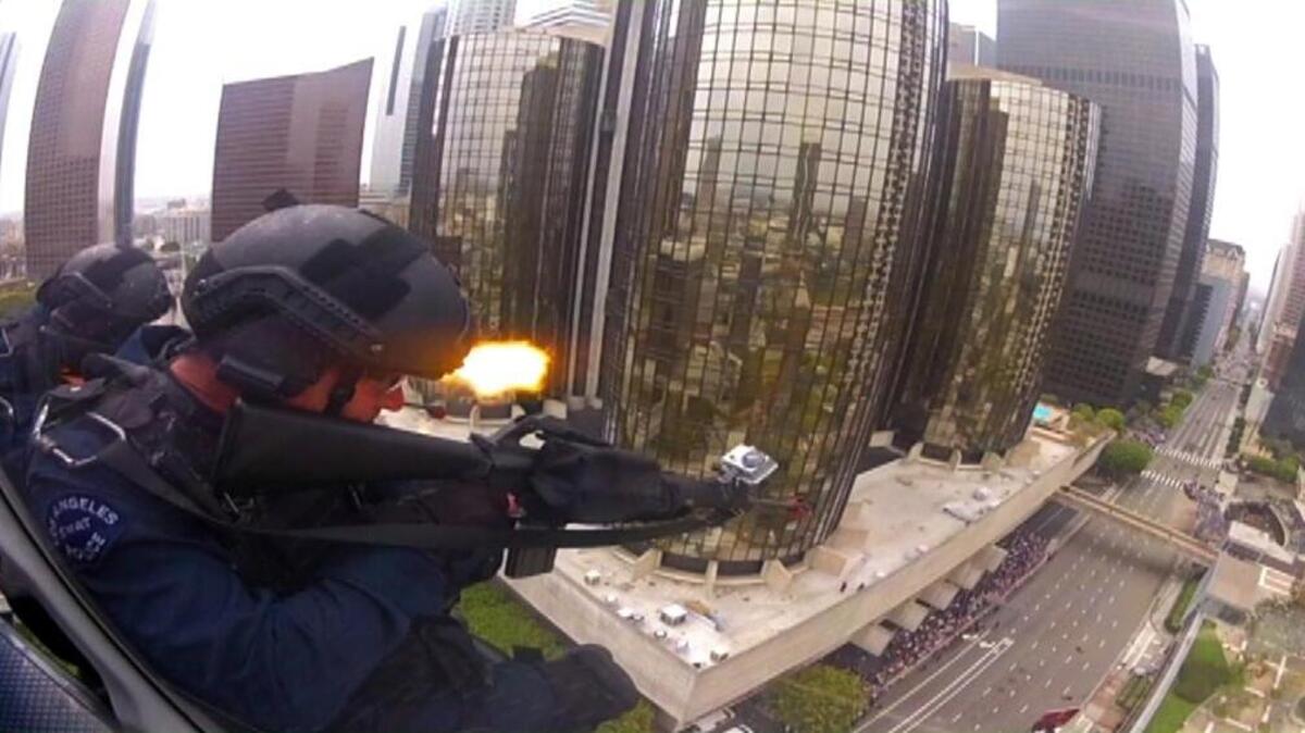 In this 2013 still frame from a video, LAPD officers fire blank rounds from a helicopter in a drill simulating a terrorist attack. After years of sending military equipment to civilian police departments, Washington has asked for some of it back.