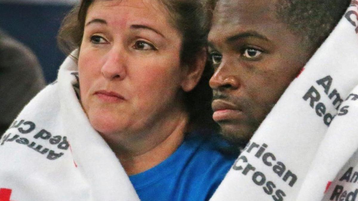 Displaced South Houston residents huddle underneath Red Cross blankets at the George Brown Convention Center in Houston on Monday, Aug. 28, 2017, in the wake of Tropical Storm Harvey. California organizations dispatched hundreds of volunteers and rescue personnel, and donated millions of dollars to the relief effort. (Louis DeLuca/The Dallas Morning News via AP)